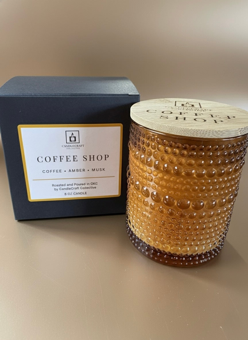 Candle labeled 'Coffee Shop' next to its packaging on a neutral background