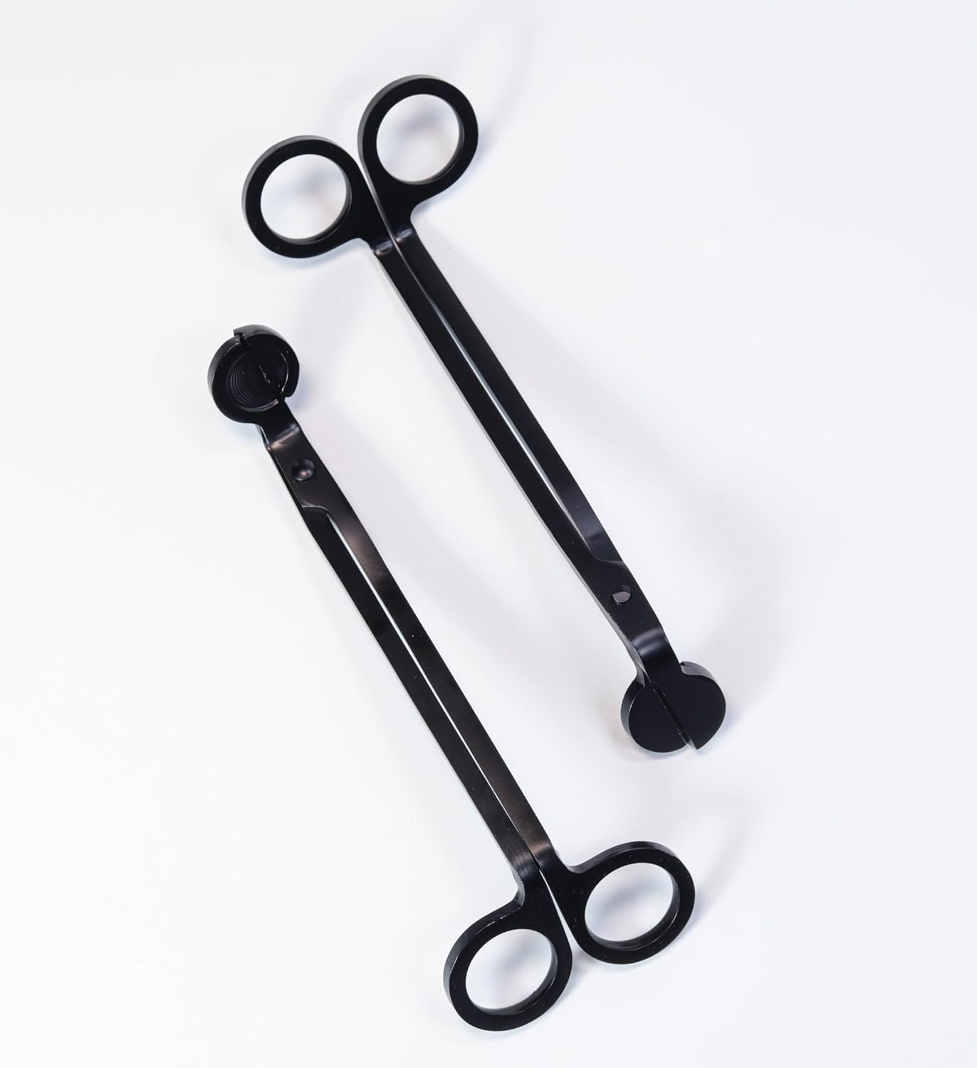 Two pairs of black wick trimmers on a white background