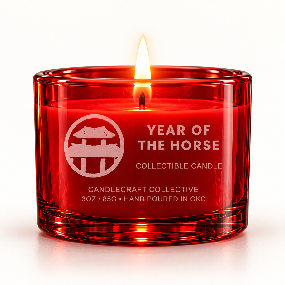 A red glass collectible candle with a single lit wick, featuring white text that reads 'YEAR OF THE HORSE' and 'COLLECTIBLE CANDLE' with the brand 'Candlecraft Collective' on the front, set against a clean white background.